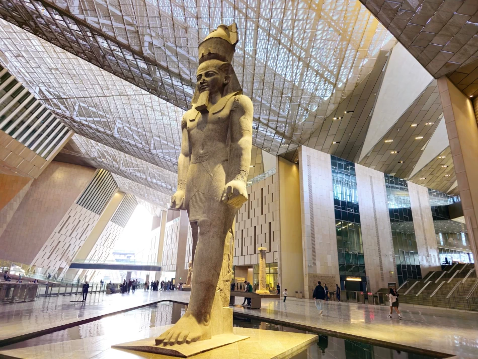 Grand Egyptian Museum in Giza displaying ancient Egyptian artifacts with pyramids behind